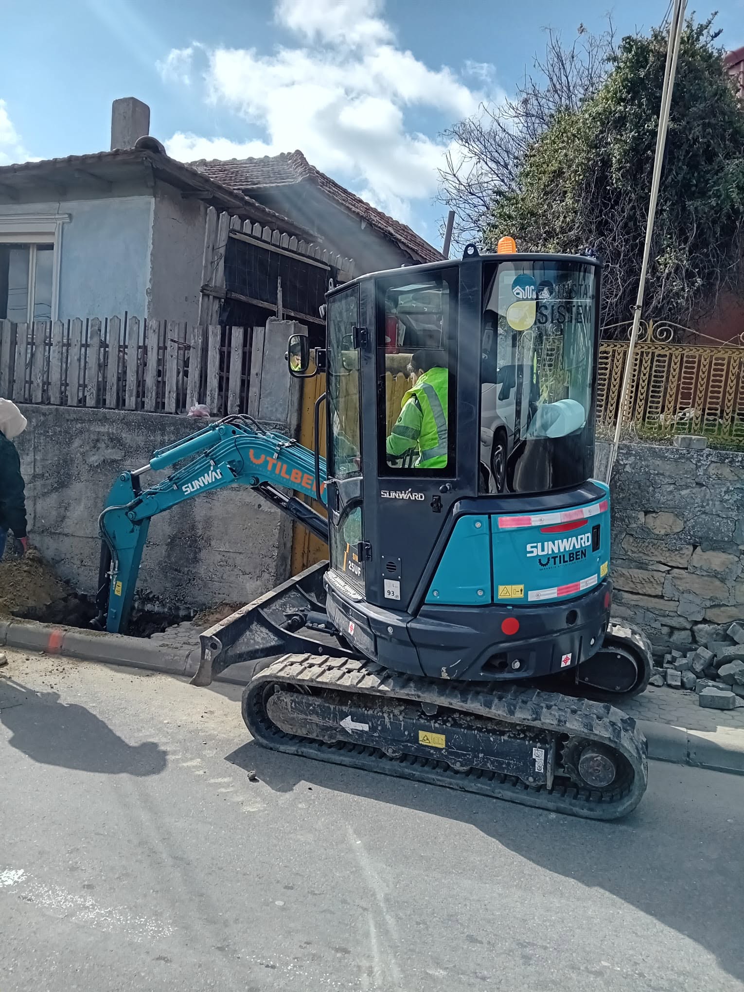 Miniexcavator Sunward lucrand in spatiu ingust, langa gard